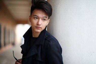 Asya genç adam sokakta bir ceket