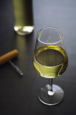 Masada şeffaf beyaz şarap şişesi var. Beyaz şarap!