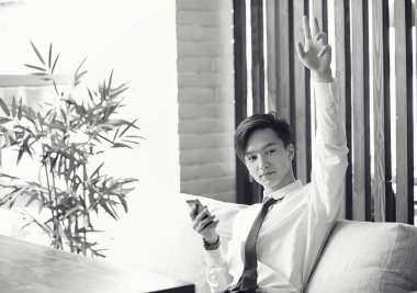 Genç Asyalı işadamı bir kafede bir ortak için bekliyor. Bu