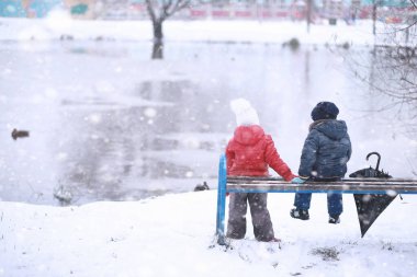 Çocuklar parkta ilk kar yürümek