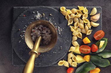 Siyah taş üzerine makarna kabukları. Allspi ile domates ve defne yaprağı