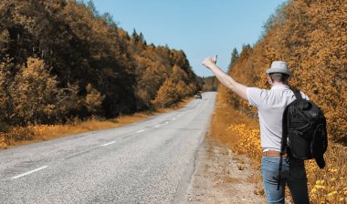 Genç bir adam doğal olarak dolaşıyor. Sırt çantasıyla seyahat eden