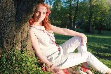 Bir sonbahar Parkta yürümek bir kız. Kızıl saçlı genç kız