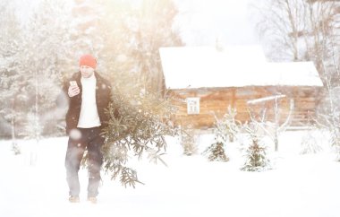 Sokakta kesilmiş bir Noel ağacı olan bir adam. N için Hazırlık