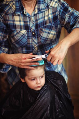 Küçük bir çocuk kuaförde kesilmiş. 