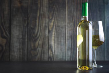 Masada şeffaf beyaz şarap şişesi var. Beyaz şarap!