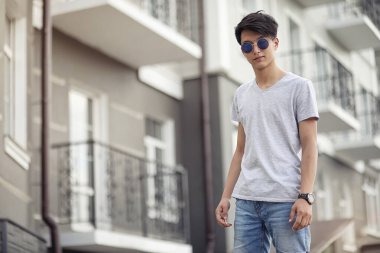 Asya genç adam giyen güneş gözlüğü açık havada