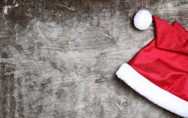 gri desenli ahşap arka plan üzerinde kırmızı santa şapka