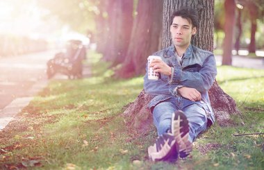 Genç bir adam öğle yemeği zamanında parkta yürür. Bir adam yürüyüşe çıktı. 