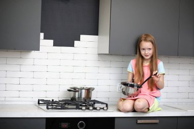 Küçük kız mutfakta. 