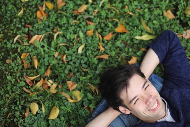 Genç bir adam öğle yemeği zamanında parkta yürür. Bir adam yürüyüşe çıktı. 
