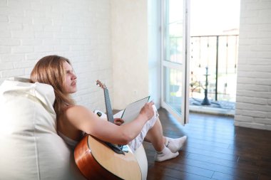 Bir gitar ile uzun saçlı Genç adam