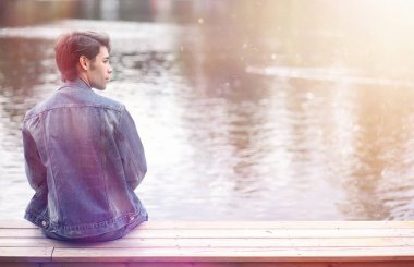 Genç bir adam öğle yemeği zamanında parkta yürür. Bir adam yürüyüşe çıktı. 