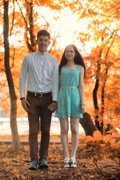 Pareja joven en un paseo en el parque de otoño — Foto de Stock