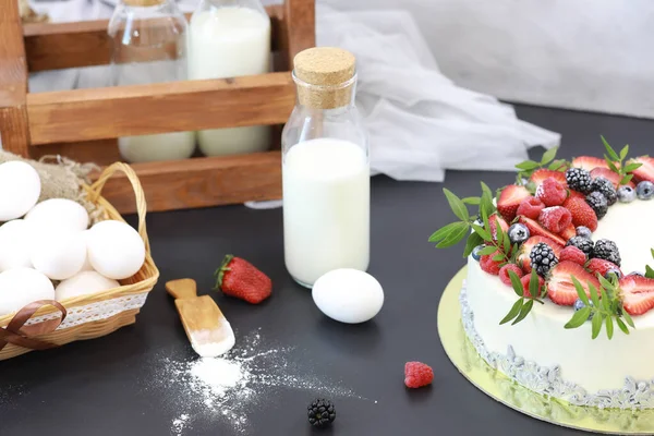 Vista de cima do bolo com creme de confeiteiro branco no garfo de prato  redondo cinza na mão feminina na mesa cinza