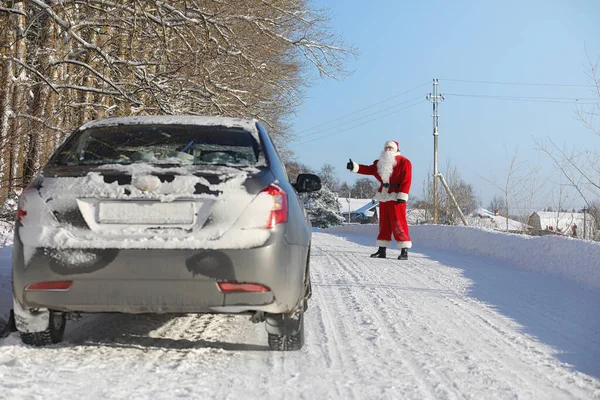 Santa Claus comes with gifts from the outside. Santa in a red su — Stock Photo, Image