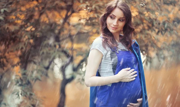 Mujer embarazada en un paseo por el parque — Foto de Stock