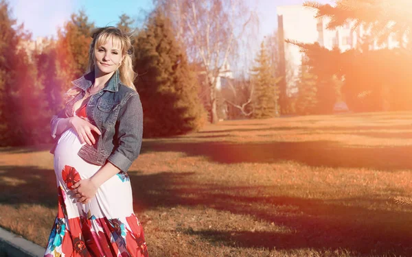 Menina grávida em um passeio no parque. Menina com uma barriga na ci — Fotografia de Stock