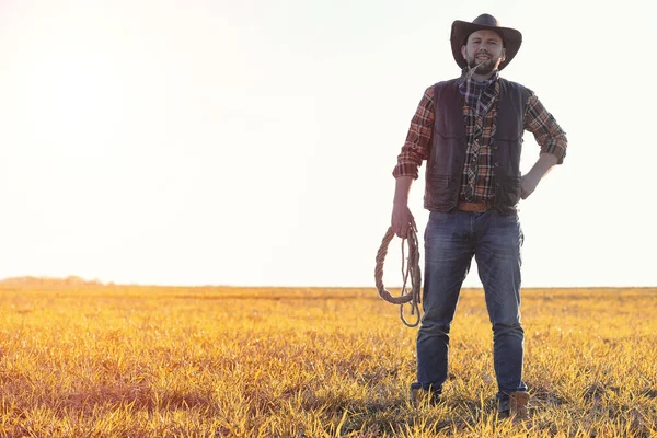Мужчина в ковбойской шляпе и лосо в поле. Американский фермер в f — стоковое фото