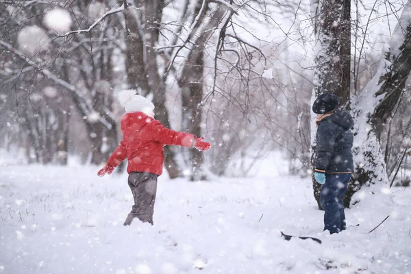 Los niños caminan en el parque primera nieve —  Fotos de Stock