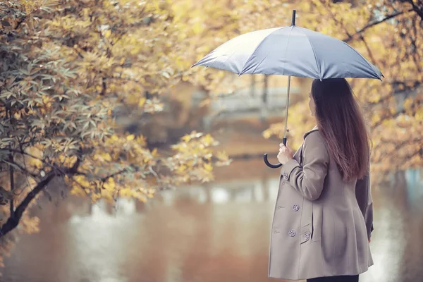 Autunno tempo piovoso e un giovane uomo con un ombrello — Foto Stock