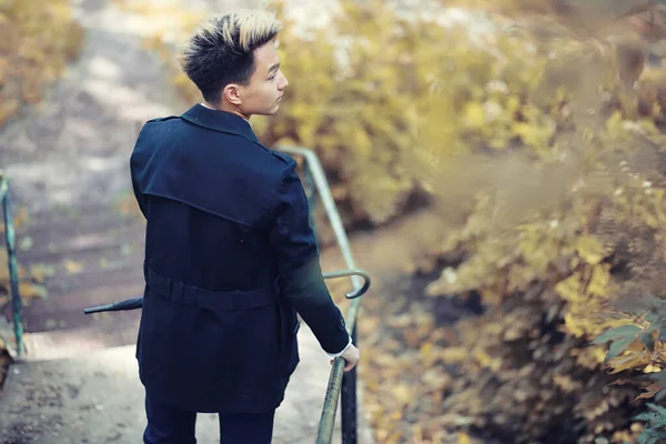 Automne temps pluvieux et un jeune homme avec un parapluie — Photo