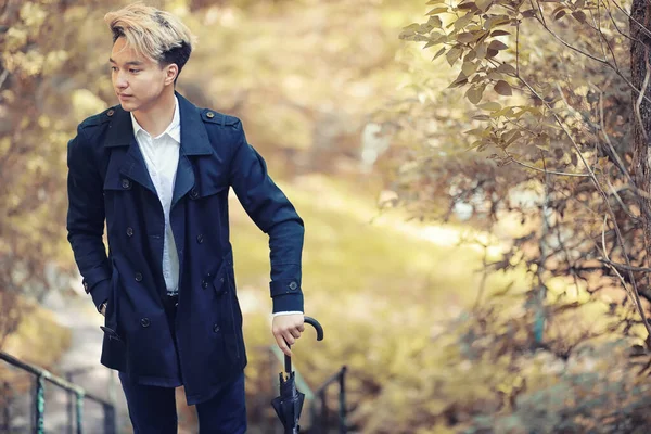 Automne temps pluvieux et un jeune homme avec un parapluie — Photo