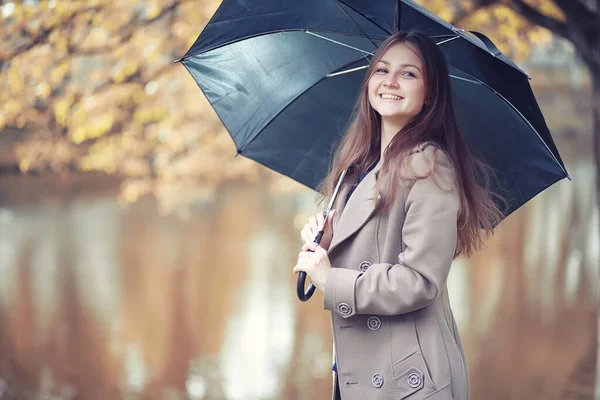 Осенняя дождливая погода и молодой человек с зонтиком — стоковое фото