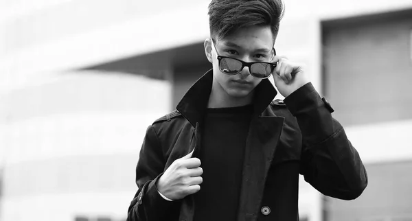 Black White photo of Asian young man outdoors posing