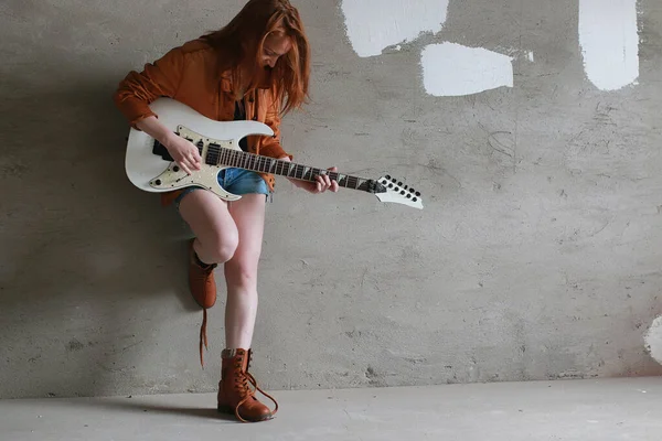 Menina ruiva jovem com uma guitarra elétrica. Músico de rock gir — Fotografia de Stock