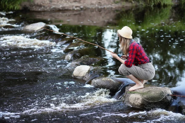 Flickan vid floden med ett fiskespö — Stockfoto