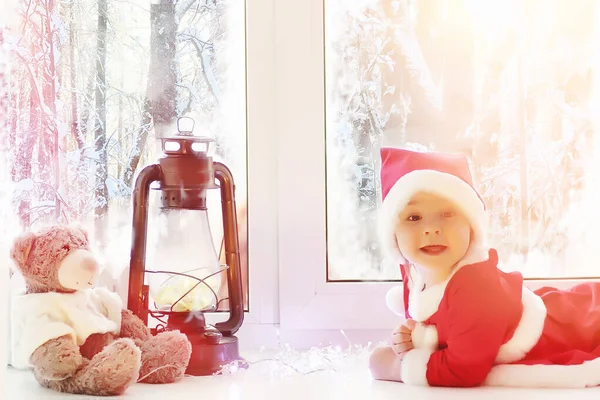 Ett barn i det nya året ser ut genom fönstret. Barn är v — Stockfoto