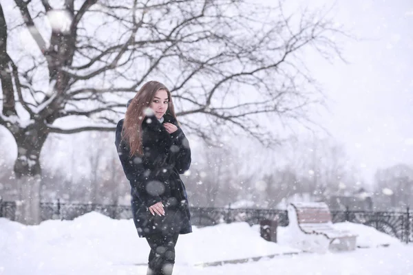 Girl in a winter park in snowfall — Stok Foto