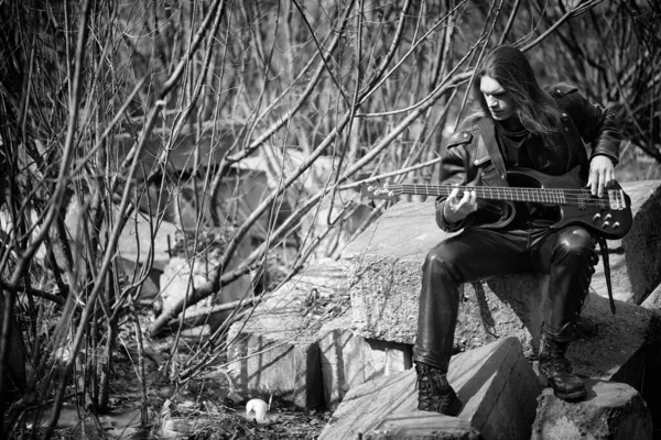 Guitarrista de rock ao ar livre. Um músico com uma guitarra baixo em um leath — Fotografia de Stock