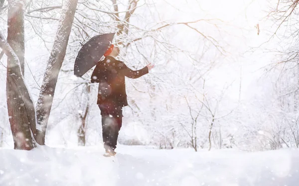 Un hombre en un paseo por el parque. Joven con en el invierno snowfa —  Fotos de Stock