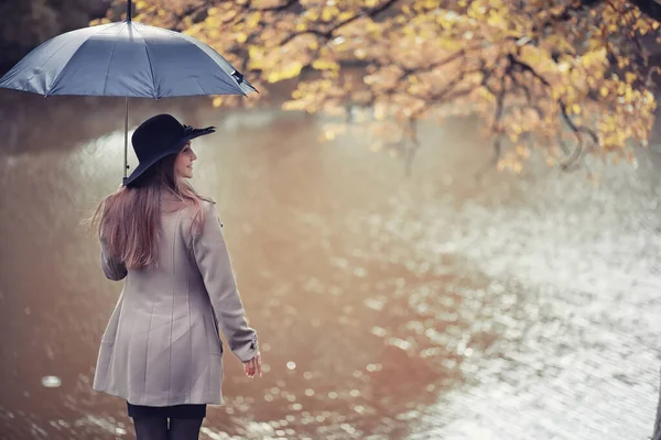 Autunno tempo piovoso e un giovane uomo con un ombrello — Foto Stock