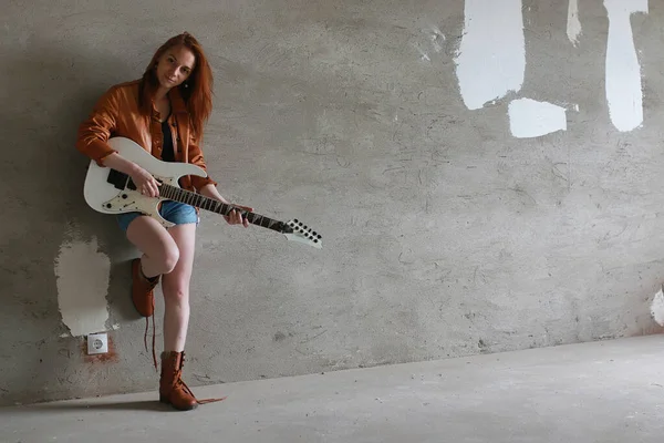 Joven pelirroja con una guitarra eléctrica. Músico de rock gir — Foto de Stock