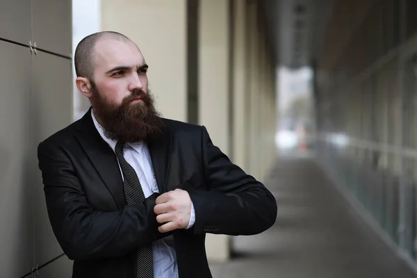A bald bearded man in a suit