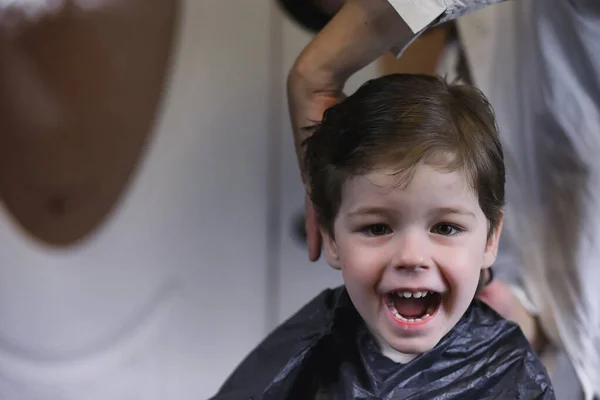 Fodrász és fiú. A fiú csinál a haját. Vágott haj gyermeke i — Stock Fotó