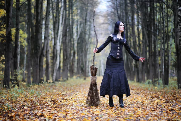 Une femme en costume de sorcière dans une forêt — Photo