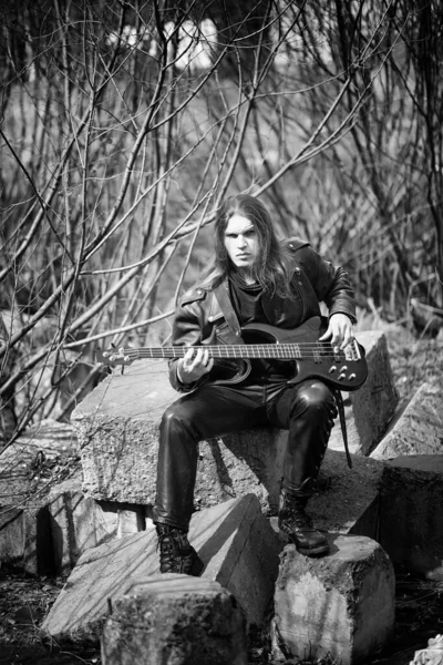 Guitarrista de rock ao ar livre. Um músico com uma guitarra baixo em um leath — Fotografia de Stock