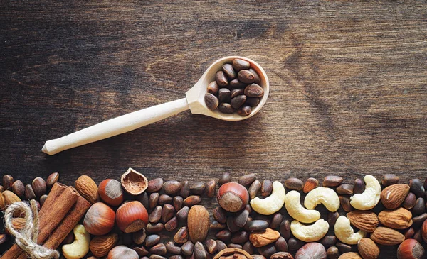 Olika nötter på ett träbord. Ceder, cashew, hasselnöt, walnu — Stockfoto