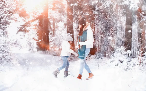 Una familia joven para dar un paseo. Mamá y su hija están caminando en un winte — Foto de Stock