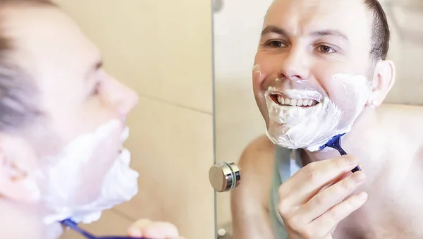 En man rakar sig i badrummet på morgonen. — Stockfoto