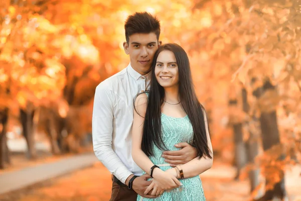 Pareja joven en un paseo en el parque de otoño — Foto de Stock