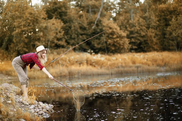 Fille en automne avec une canne à pêche — Photo