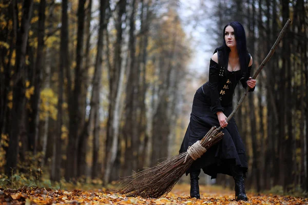 Uma mulher de fato de bruxa numa floresta — Fotografia de Stock