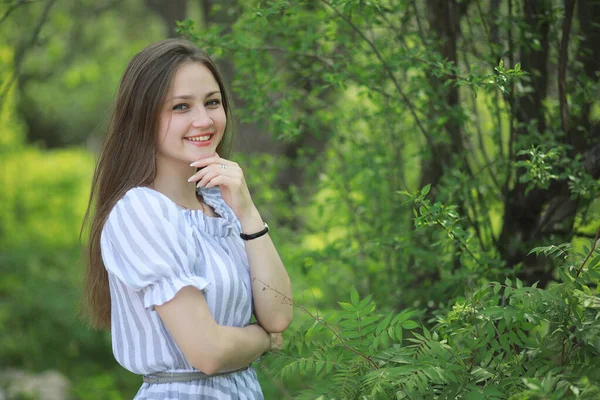 Uma menina em um parque verde primavera — Fotografia de Stock