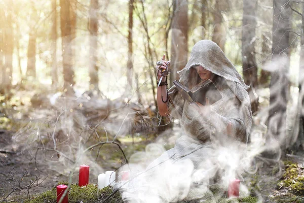 En man i en Kaftan tillbringar en ritual i en mörk skog — Stockfoto