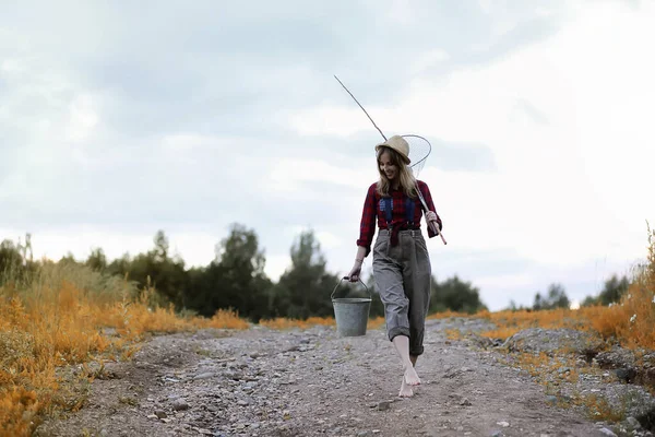 Chica en otoño con una caña de pescar — Foto de Stock